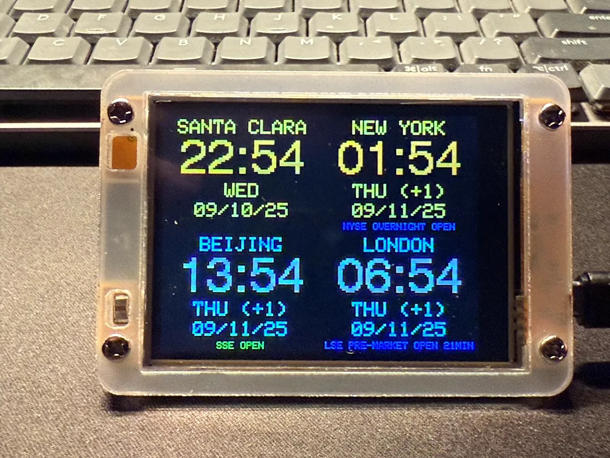 ESP32 world clock on a desk showing four cities